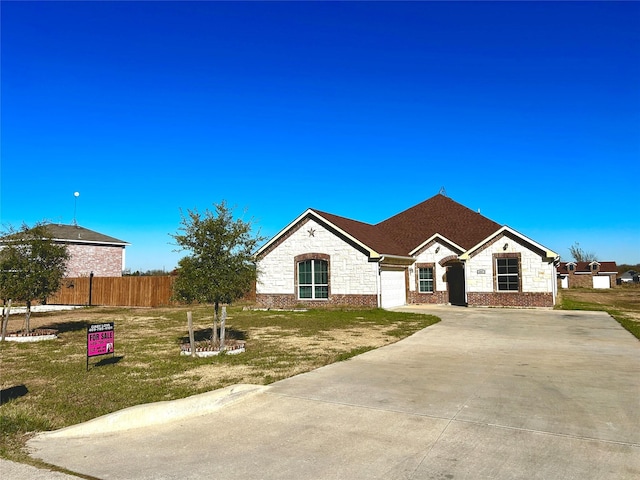 ranch-style home featuring a front yard and a garage