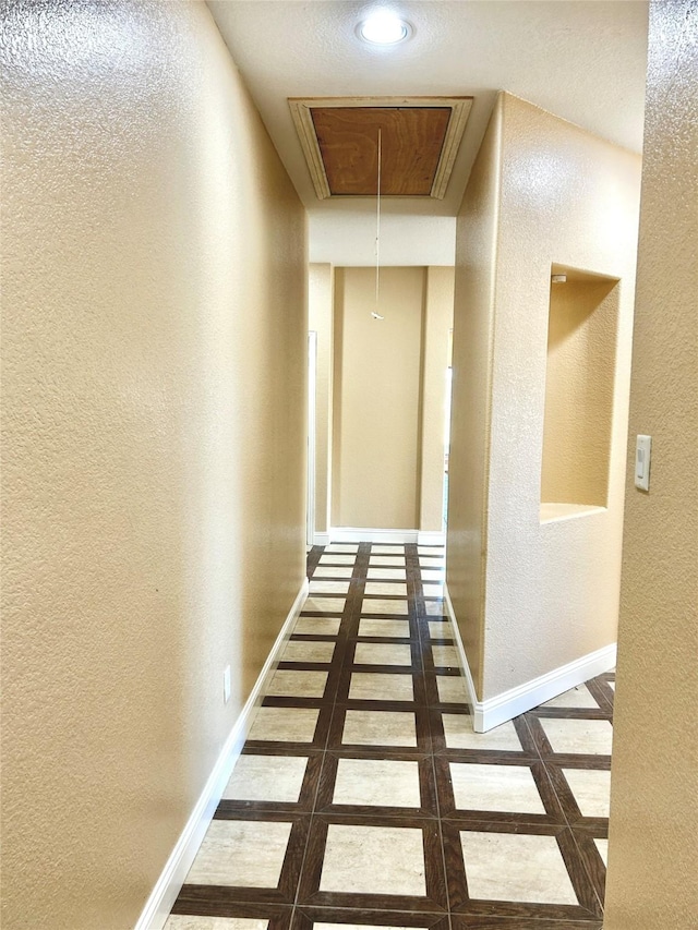 hallway featuring dark tile patterned floors