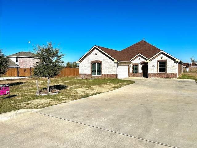 single story home featuring a garage and a front lawn