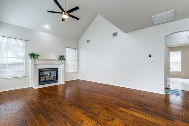 unfurnished living room with high vaulted ceiling, ceiling fan, dark hardwood / wood-style floors, and a wealth of natural light