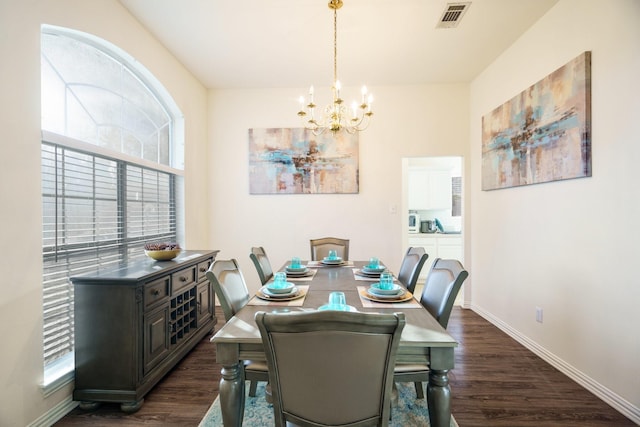 dining area featuring dark hardwood / wood-style flooring and an inviting chandelier