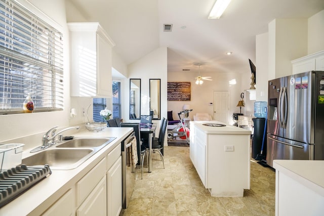 kitchen with stainless steel appliances, ceiling fan, sink, white cabinets, and lofted ceiling