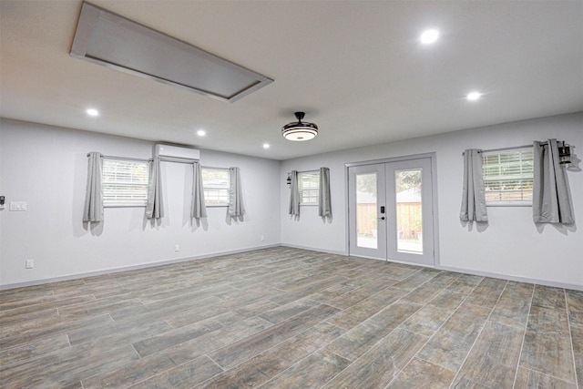 spare room featuring french doors, light wood-type flooring, and plenty of natural light