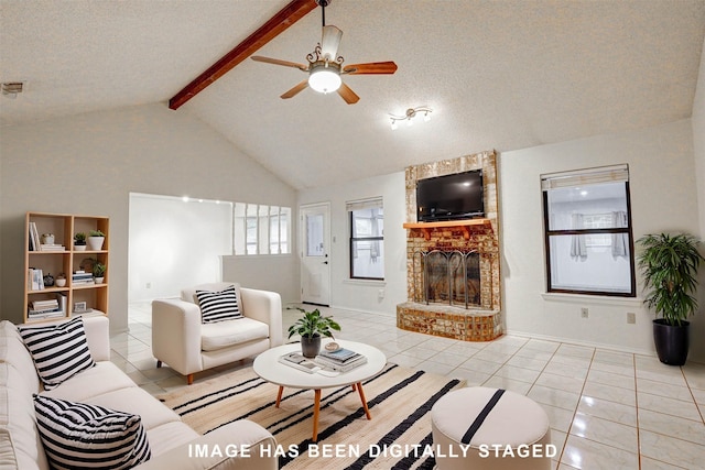 living room with beamed ceiling, light tile patterned flooring, and a textured ceiling