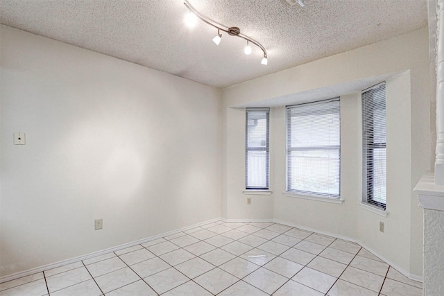 tiled empty room with a textured ceiling