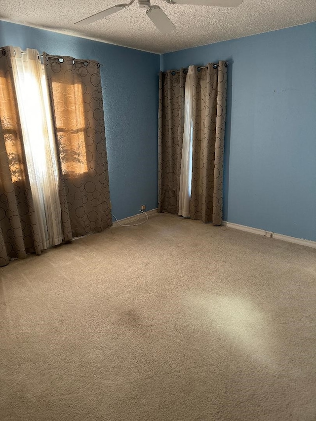 unfurnished room with carpet flooring, a textured ceiling, and ceiling fan