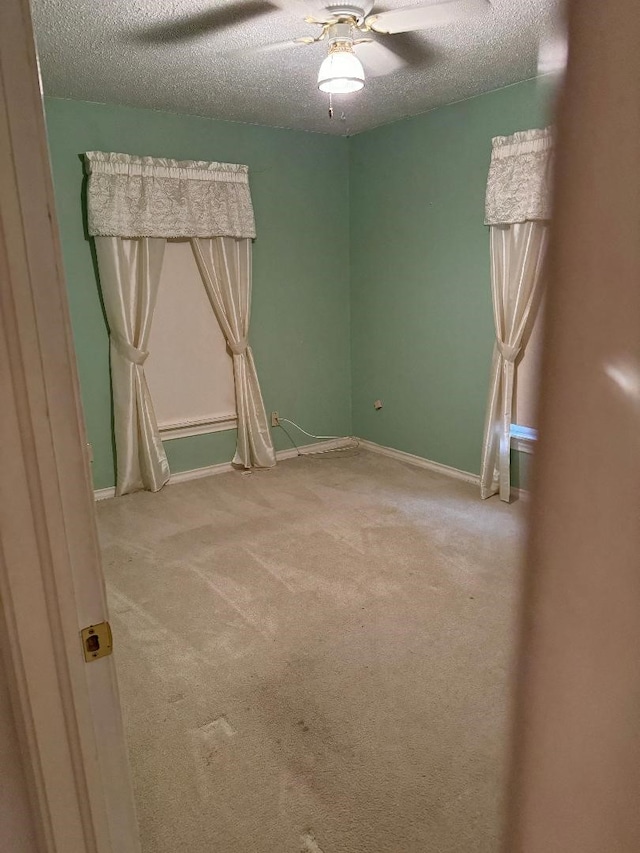 carpeted empty room with a textured ceiling and ceiling fan