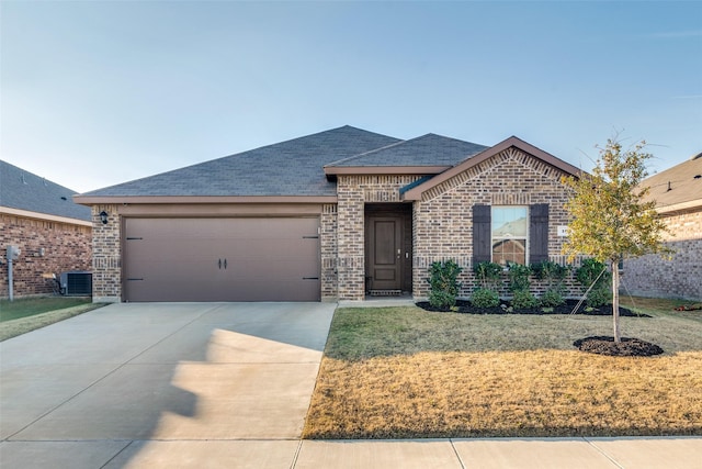 view of front of house with a garage, central air condition unit, and a front lawn