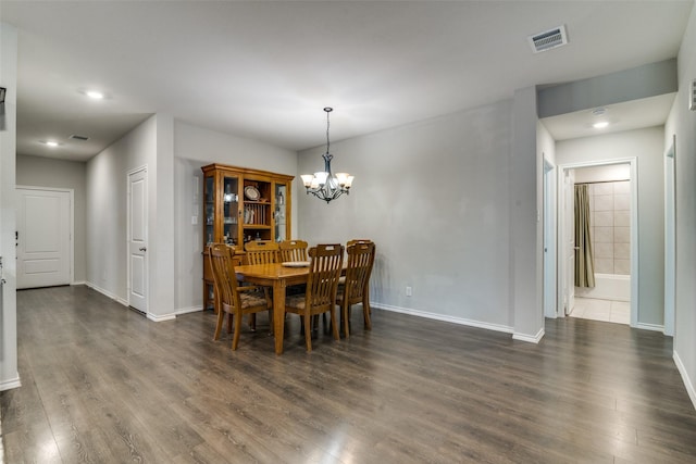 dining room featuring a notable chandelier and dark wood-type flooring