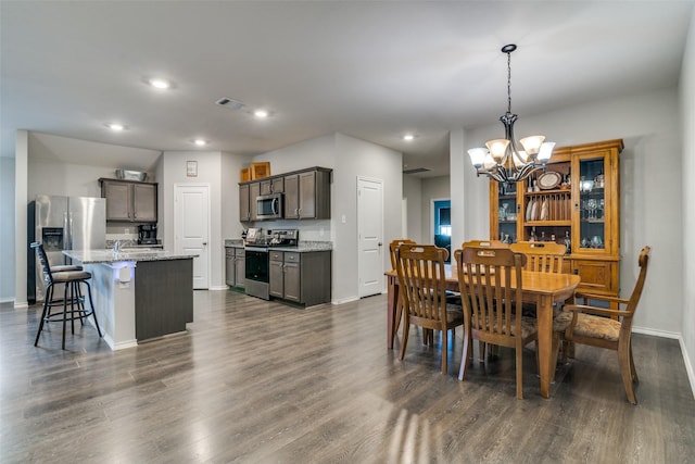 dining area with dark hardwood / wood-style floors and a notable chandelier