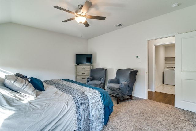 bedroom featuring washer / dryer, light colored carpet, ceiling fan, and lofted ceiling