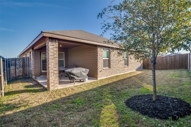 back of house with a yard and a patio