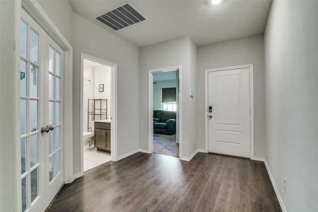 hall featuring a healthy amount of sunlight, french doors, and dark wood-type flooring