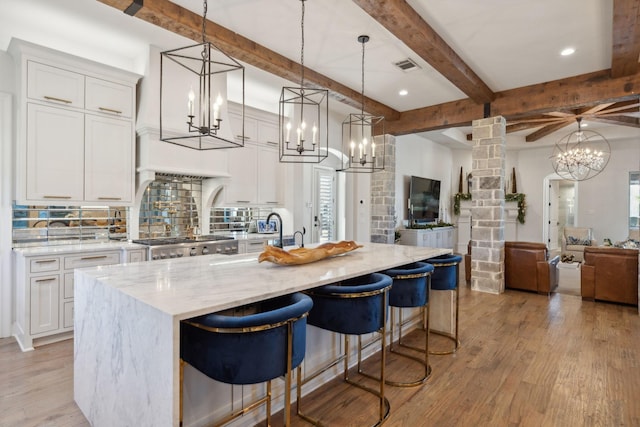 kitchen with decorative columns, white cabinets, and pendant lighting