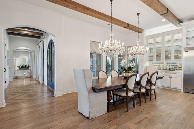 dining area featuring hardwood / wood-style floors, a notable chandelier, and beam ceiling