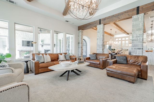 carpeted living room featuring beamed ceiling, decorative columns, and a chandelier