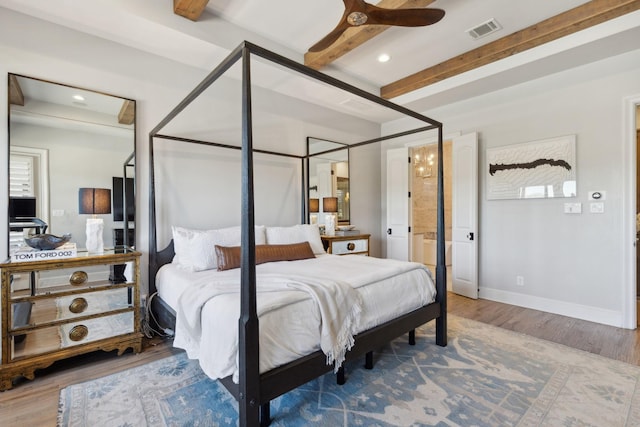 bedroom featuring beam ceiling, ceiling fan, ensuite bathroom, and hardwood / wood-style flooring