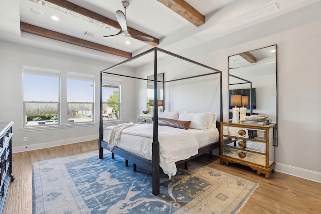 bedroom featuring beamed ceiling, ceiling fan, and light hardwood / wood-style flooring