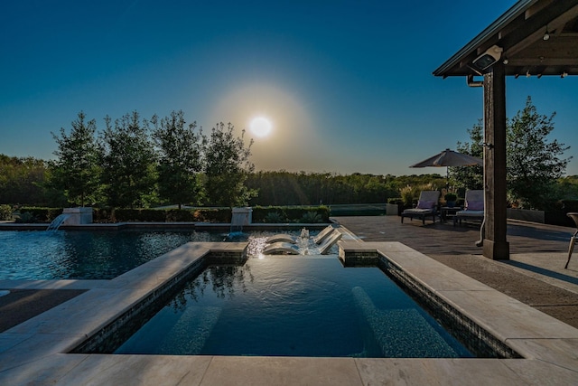 view of swimming pool featuring pool water feature, a jacuzzi, and a patio