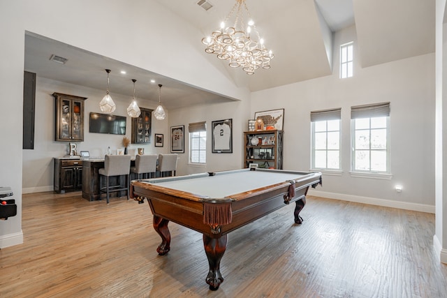 rec room featuring bar, light hardwood / wood-style flooring, a high ceiling, and pool table