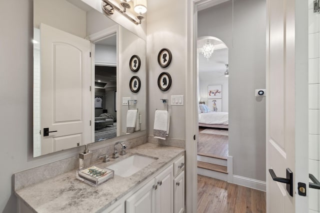 bathroom with hardwood / wood-style floors, ceiling fan, and vanity