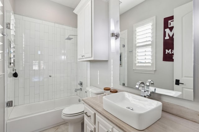 full bathroom with tile patterned flooring, tiled shower / bath combo, toilet, and vanity