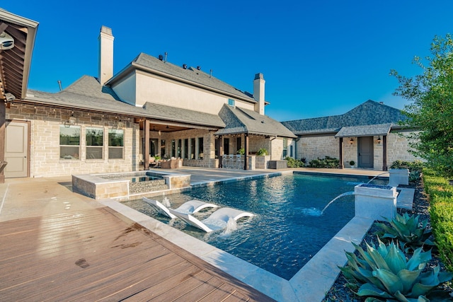 view of pool with an in ground hot tub, pool water feature, and a patio area