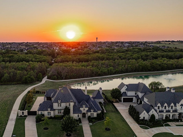 aerial view at dusk featuring a water view