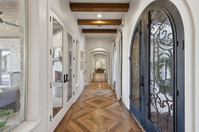 foyer featuring parquet flooring, french doors, and beam ceiling