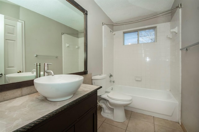 full bathroom with tile patterned floors, toilet, a textured ceiling, vanity, and tiled shower / bath combo