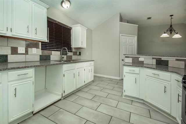 kitchen featuring white cabinetry, dark stone counters, sink, and decorative backsplash