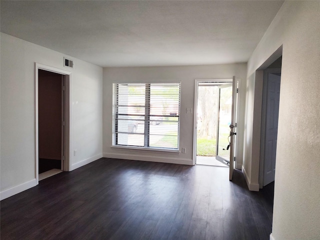 empty room with dark hardwood / wood-style flooring