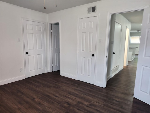 unfurnished bedroom with dark hardwood / wood-style flooring