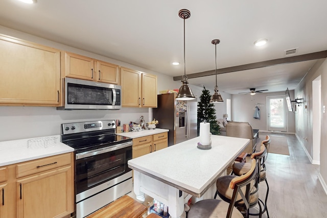 kitchen with hanging light fixtures, appliances with stainless steel finishes, ceiling fan, and light brown cabinetry