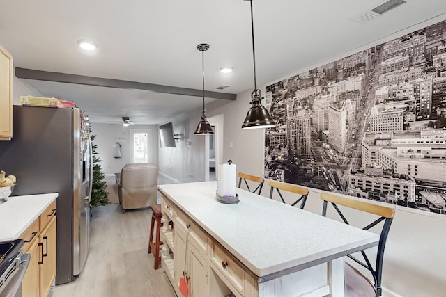 kitchen featuring stainless steel refrigerator, ceiling fan, light hardwood / wood-style flooring, stove, and pendant lighting