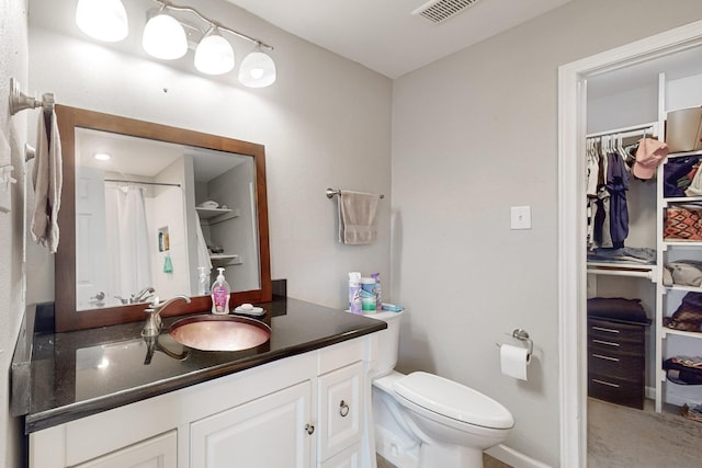 bathroom with a shower with shower curtain, vanity, and toilet