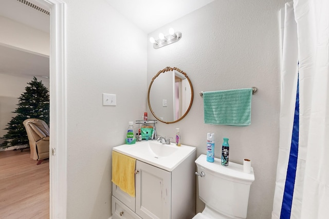 bathroom featuring hardwood / wood-style floors, vanity, and toilet