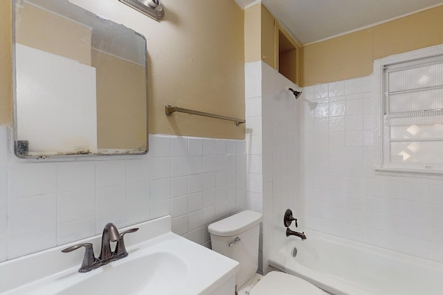 full bathroom with toilet, vanity, tile walls, and tiled shower / bath