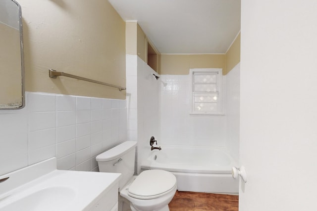 full bathroom with vanity, toilet, tile walls, and tiled shower / bath combo