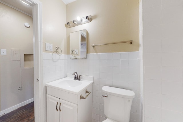 bathroom with toilet, vanity, tile walls, and hardwood / wood-style flooring