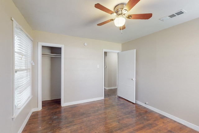 unfurnished bedroom featuring dark hardwood / wood-style flooring, a closet, and ceiling fan