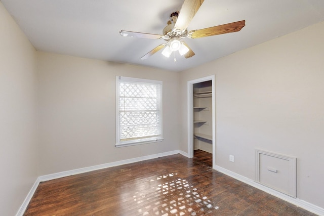 empty room featuring dark hardwood / wood-style flooring and ceiling fan