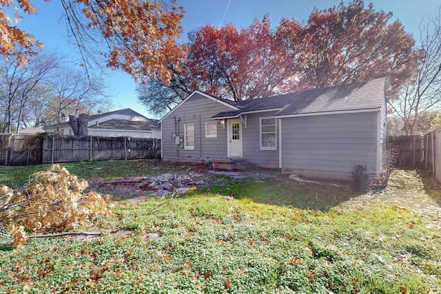 rear view of house featuring a yard