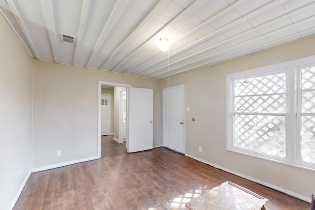 unfurnished room featuring plenty of natural light and dark hardwood / wood-style floors