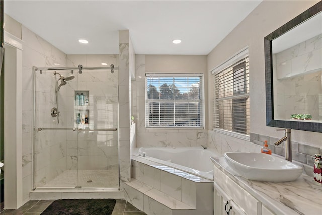 bathroom with tile patterned floors, vanity, and shower with separate bathtub