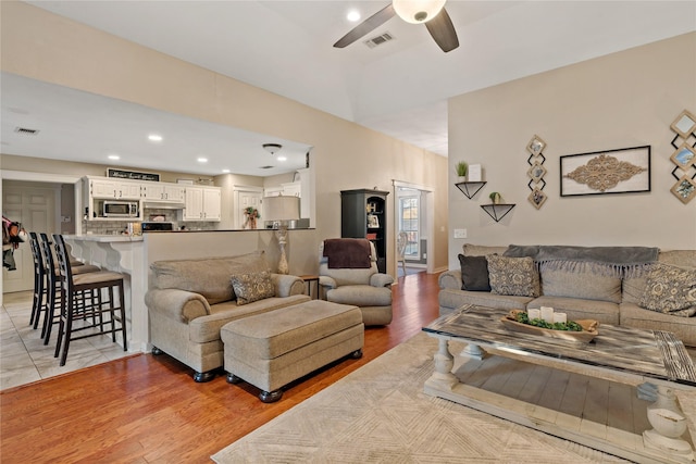 living room with ceiling fan and light hardwood / wood-style flooring