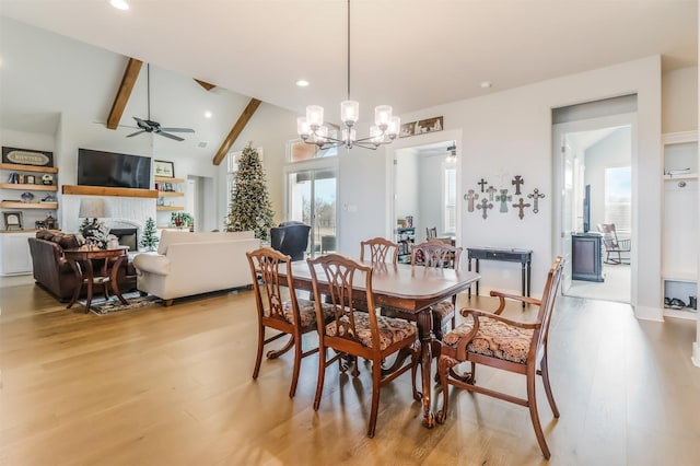 dining room with beamed ceiling, ceiling fan with notable chandelier, high vaulted ceiling, and light hardwood / wood-style flooring