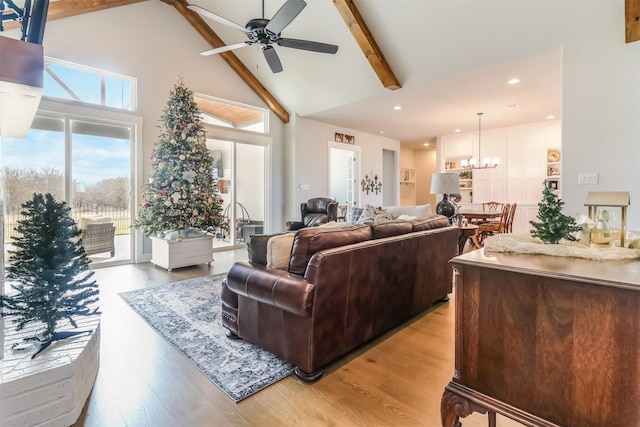 living room with ceiling fan with notable chandelier, beam ceiling, high vaulted ceiling, and light hardwood / wood-style flooring