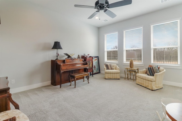 living area with light colored carpet and ceiling fan