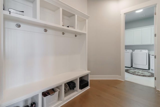 mudroom with hardwood / wood-style flooring and washing machine and clothes dryer